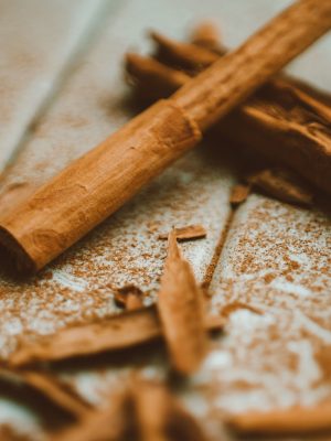 A detailed close-up image of cinnamon sticks and ground cinnamon on a wooden surface, highlighting texture and aroma.